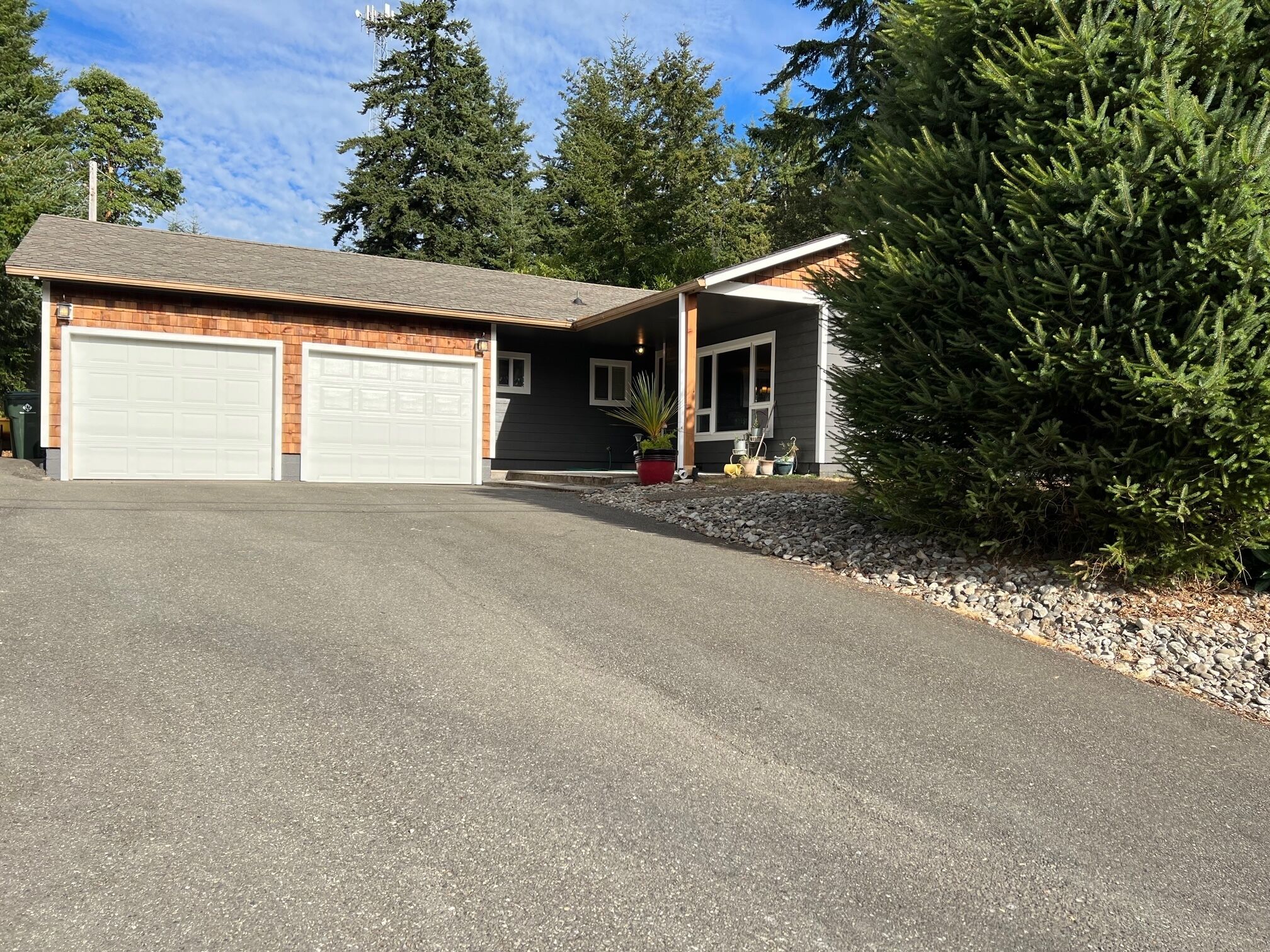 A two-story house with a garage, a covered porch, and a driveway.