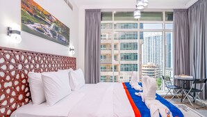 A hotel room with a large bed, a view of a cityscape, a decorative wall panel, and a small table with chairs. - ZAPBED House OPT 701&34 (Dubai)