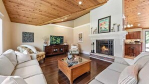 A spacious living room with a high ceiling, a fireplace, and a television. - Perfect retreat for multi-generational families! Sat-Saturday lakeside rental. (Three Oaks)