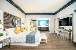 Une chambre d’hôtel moderne, dotée d’un grand lit, d’un bureau et d’une télévision.