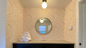 A bathroom with a vanity, a mirror, and a towel rack with towels. - Peaceful full home in the heart of Southside Flats. (Pittsburgh)
