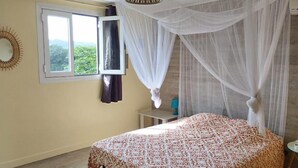 Una camera da letto con un letto, una finestra, un comodino e una lampada a sospensione.