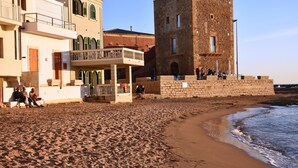 Un edificio costero con balcón que da a la playa.