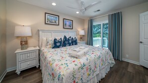 A bedroom with a large bed, two bedside lamps, a ceiling fan, and a window with curtains. - 2 BR + Loft/2BA Tarpon Pond Cottage! Great Views! 1 Dog Friendly! (Seabrook Island)