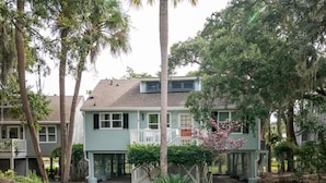 A two-story house with a front porch, surrounded by mature trees and a well-maintained garden. - 2 BR + Loft/2BA Tarpon Pond Cottage! Great Views! 1 Dog Friendly! (Seabrook Island)