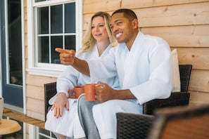 Two people sitting on wicker chairs outside a building with wooden siding. - Waterfront Retreat w Dock, Firepit & Boat Access (Belhaven)