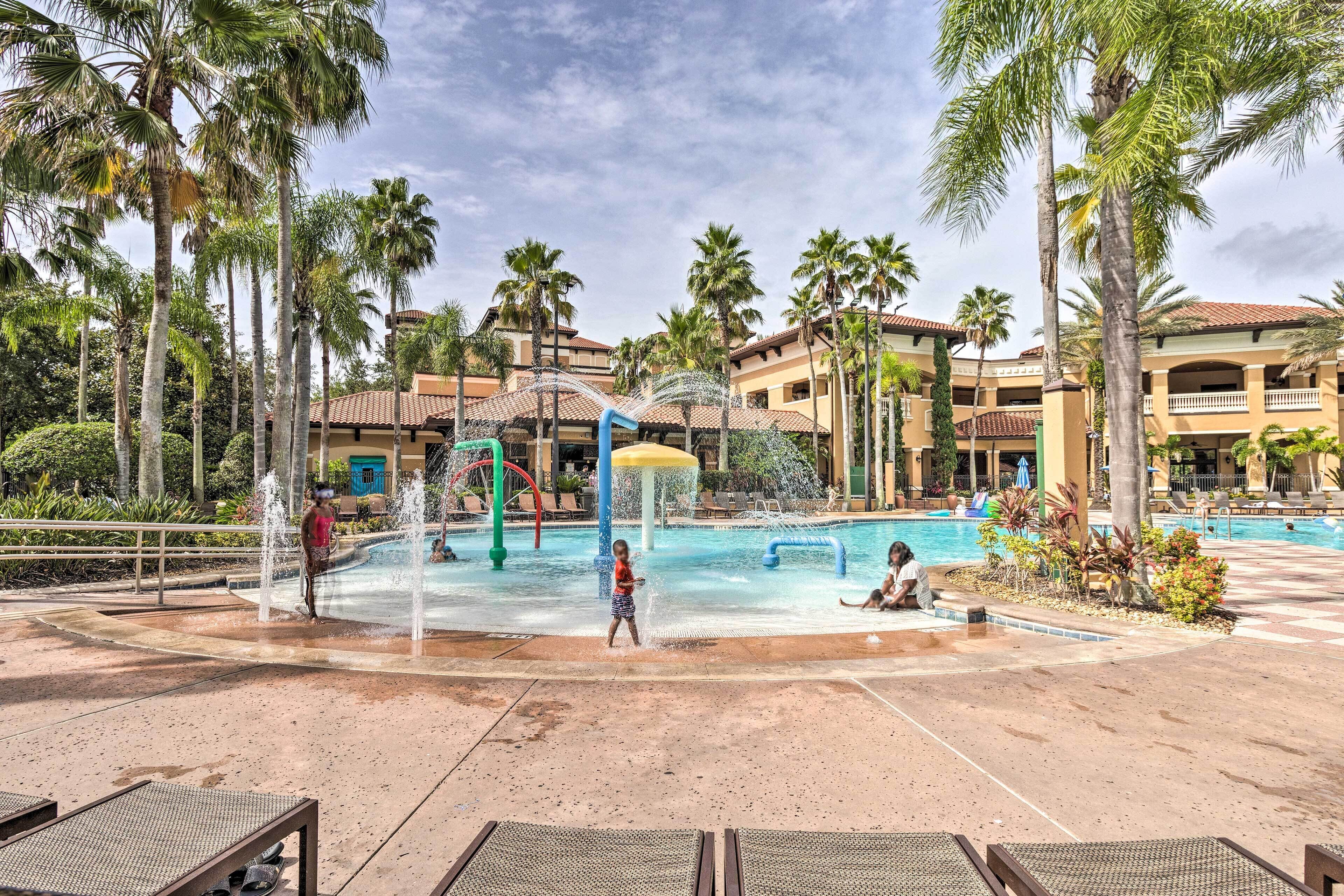 Ein Poolbereich eines Resorts mit Palmen, einer Wasserspielanlage und Liegestühlen.