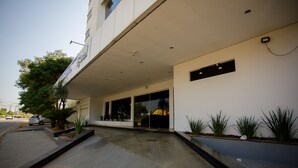 A modern building with a flat facade, large windows, and a clean entrance area with a pathway leading to the doors. - Hotel Atrium Express (Parauapebas)