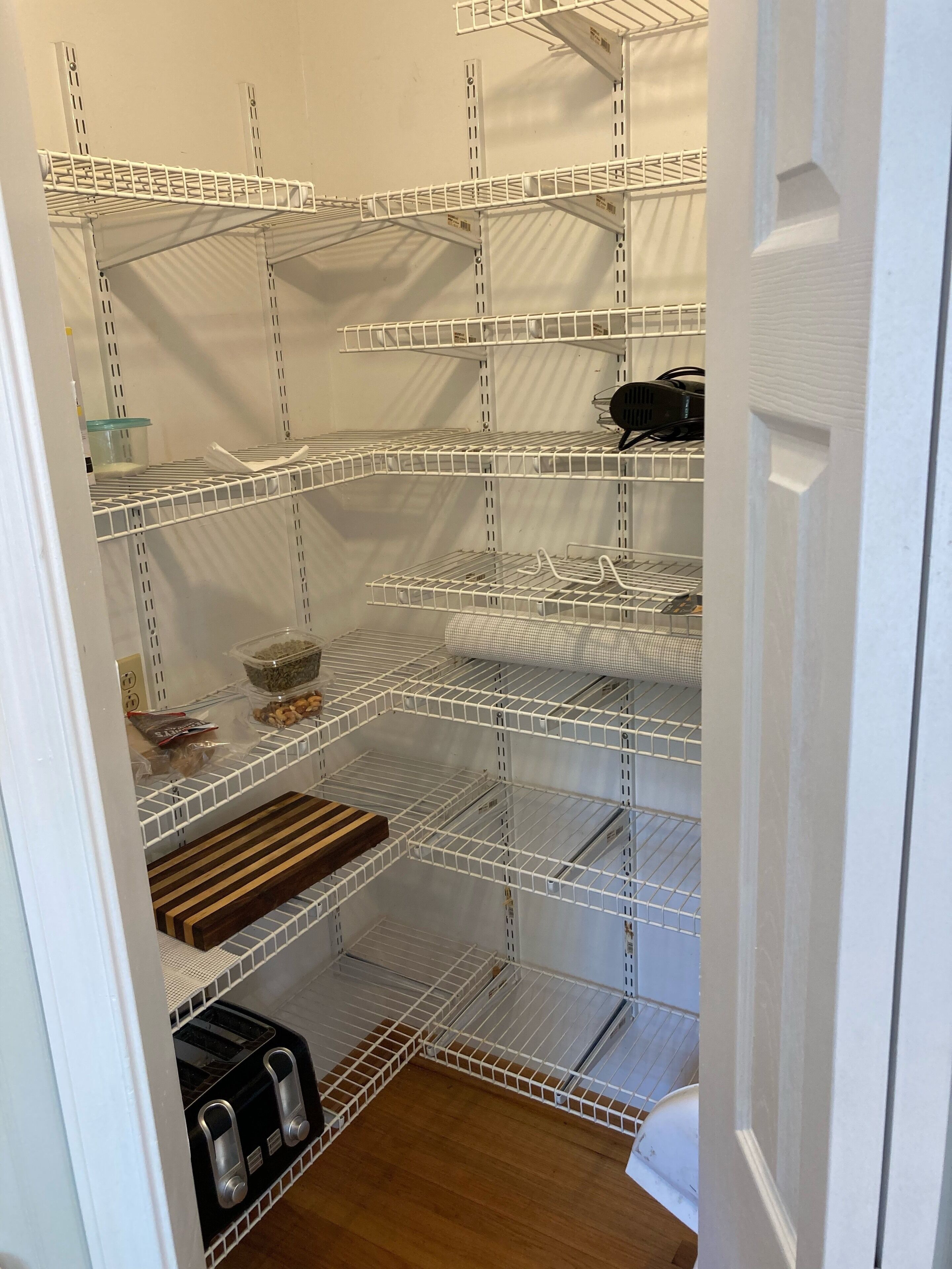 Un placard de rangement doté de plusieurs étagères et d’un four encastré.