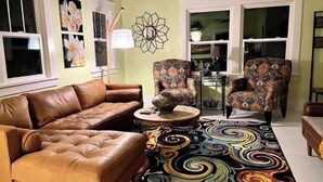 A living room with a brown leather sofa, patterned armchairs, a coffee table, and a colorful rug. - boho noc GAME ROOM pets welcome king beds freeW/D (Amarillo)