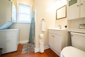Ein kleines Badezimmer mit Toilette, Waschbecken und einem Fenster mit Jalousien.