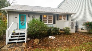 A single-story house with a turquoise front door, white exterior, and a small porch with steps. - Jo Mac Cottage- Quiet Home near UNC Chapel Hill (Chapel Hill)
