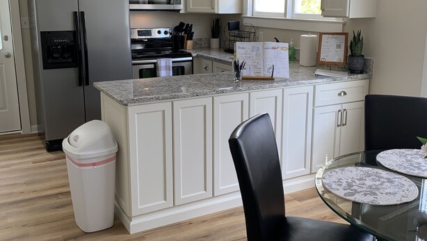 A modern kitchen with white cabinetry, stainless steel appliances, and a granite countertop. - Jo Mac Cottage- Quiet Home near UNC Chapel Hill (Chapel Hill)