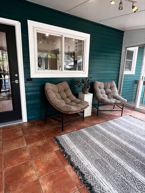 Relax in a stylish room with a large window, two comfortable chairs, and a cozy side table.
