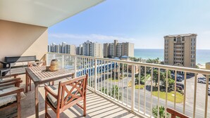 A balcony with a table and chairs, overlooking a cityscape and the ocean. - New Low Fall/Winter Prices! 2BR2BA Beauty in Gulf Shores Crystal Tower 608 (Gulf Shores)