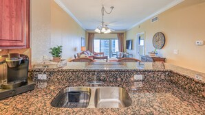A kitchen with granite countertops, a built-in sink, and a coffee maker. - New Low Fall/Winter Prices! 2BR2BA Beauty in Gulf Shores Crystal Tower 608 (Gulf Shores)