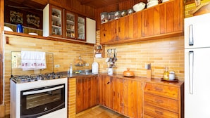 Eine Küche mit Holdekor, einem Gasherd und einem Kühlschrank.