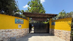 A gated entrance with a yellow wall and a tiled floor. - Amazing and comfortable country house. Very close to the Rozo small town. (Palmira Rozo)