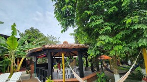 A gazebo with a tiled roof, surrounded by lush greenery and a hammock. - Amazing and comfortable country house. Very close to the Rozo small town. (Palmira Rozo)