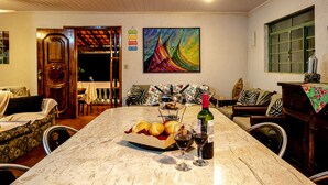 Un comedor con una mesa de mármol, un cuadro y una botella de vino.