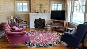 Una sala de estar con chimenea, televisión y dos sillones.