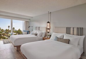 A hotel room with two beds, a nightstand, a lamp, and a view of the outdoors. - The Pierside (Santa Monica)