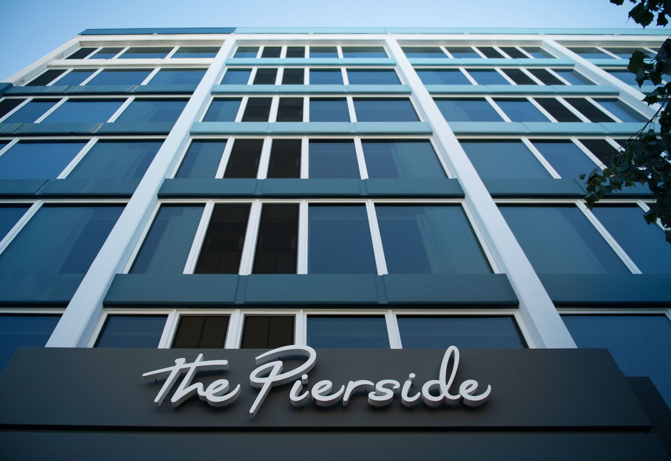 Een modern gebouw met een bord waarop 'the Pierside' staat.