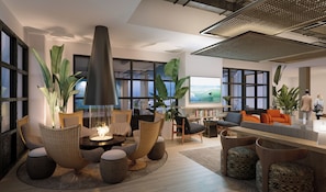 A modern living room with a fireplace, comfortable seating, large windows, and a bookshelf. - The Pierside (Santa Monica)