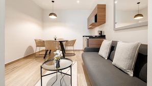 A modern living room with a grey sofa, a round coffee table, wicker chairs, and a dining table. - Noma Condesa Mexico City by Lumina (Mexico City)