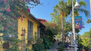A yellow building with a balcony, surrounded by greenery and a clear sky. - Waterfront Marina District  Luxury Home & In-law Suite (Gulfport)