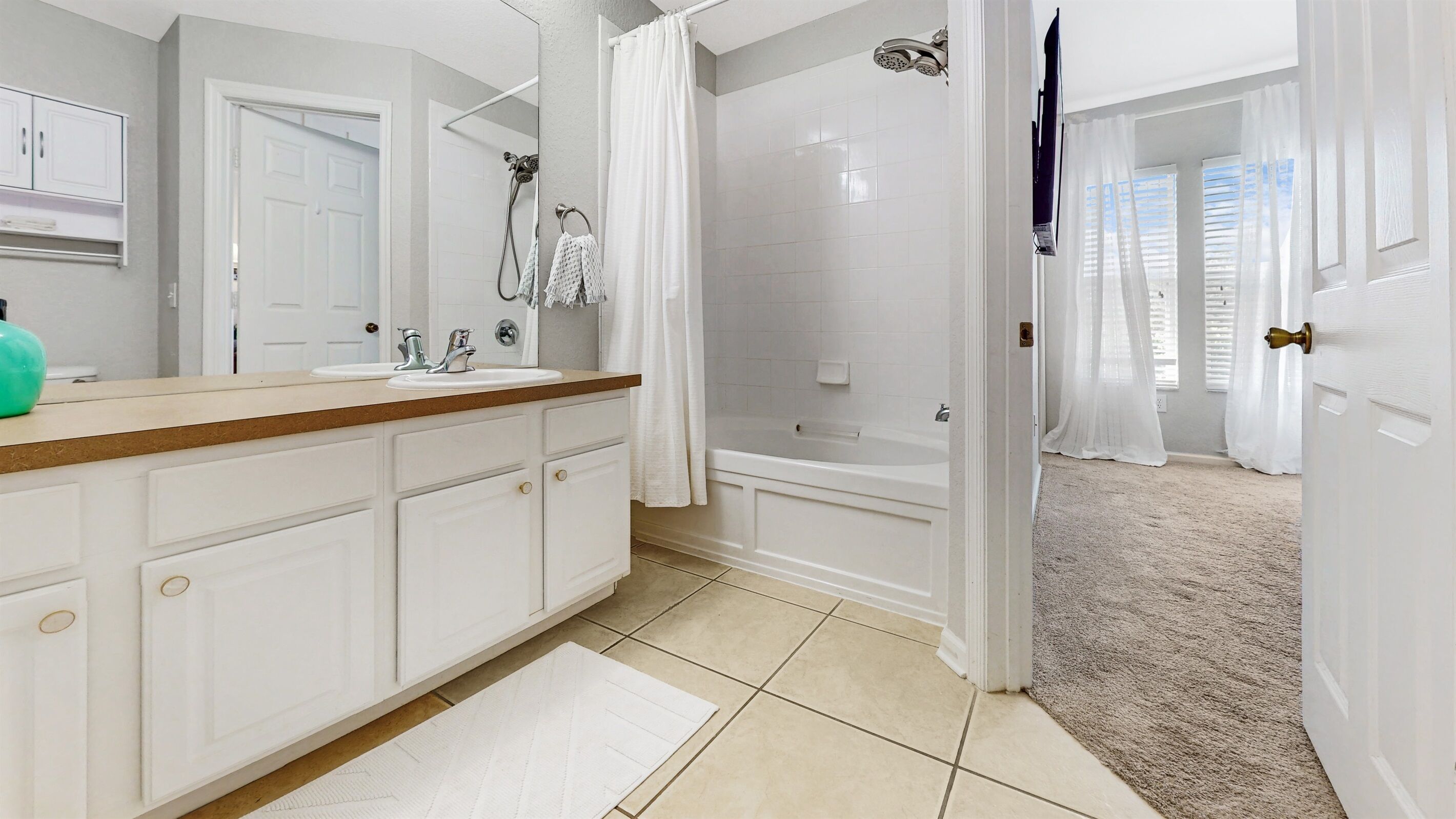Een moderne badkamer met een ruime wastafel, een douche en een inloopkast.