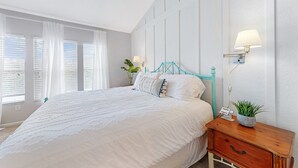 A bedroom with a large bed, white bedding, a teal headboard, a bedside table with a lamp, and a small plant. - 3bd/3bth, Private Pool & View, 5mi to Disney Parks (Kissimmee)