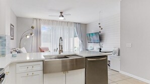 A modern kitchen with a stainless steel sink, white cabinetry, and a ceiling fan. - 3bd/3bth, Private Pool & View, 5mi to Disney Parks (Kissimmee)