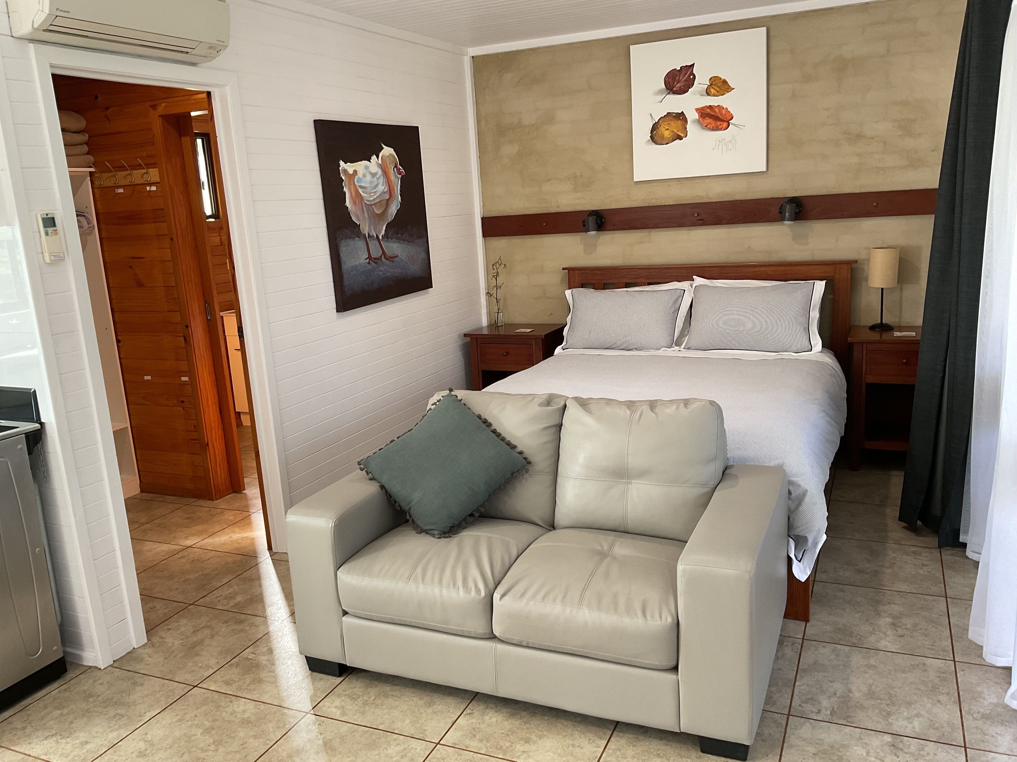 Une chambre d’hôtel avec un lit, un canapé, un tableau et une œuvre d’art accrochée au mur.