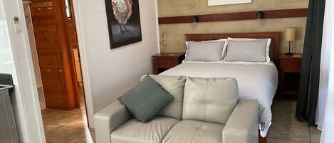 Une chambre d’hôtel avec un lit, un canapé, un tableau et une œuvre d’art accrochée au mur.