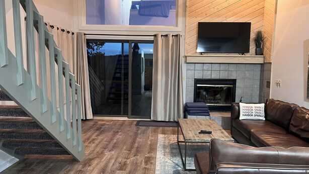 A modern living room with a fireplace, a sofa, a coffee table, and a TV.