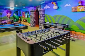 A room with two foosball tables, a pool table, and a dartboard. - Mario Game Loft & Slide · Sleeps 26 · 4mi Disney · Free Heated Pool & Spa (Kissimmee)