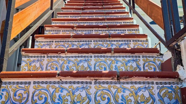 A staircase with ornate tile patterns and metal railings. - Stunning 2 BR Private Apartment with Parking (Carolina)