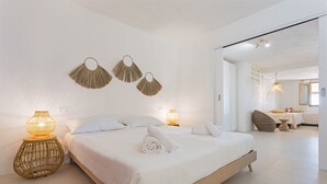A spacious bedroom with a large bed, two bedside lamps, and wall-mounted decorative fans. - Casa del Mare Blu - Seaview apartment with pool (Tertenia)