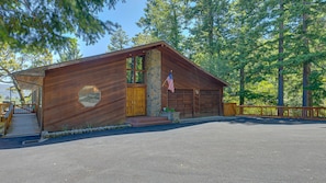 Une cabane en bois avec un mur en pierre, une porte en bois et un drapeau américain.