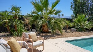 A pool area with lounge chairs and palm trees. - 4bd & Sleeps up to 10 - Saltwater Pool, Sunloungers, Mini Golf & Game Room (Indio)
