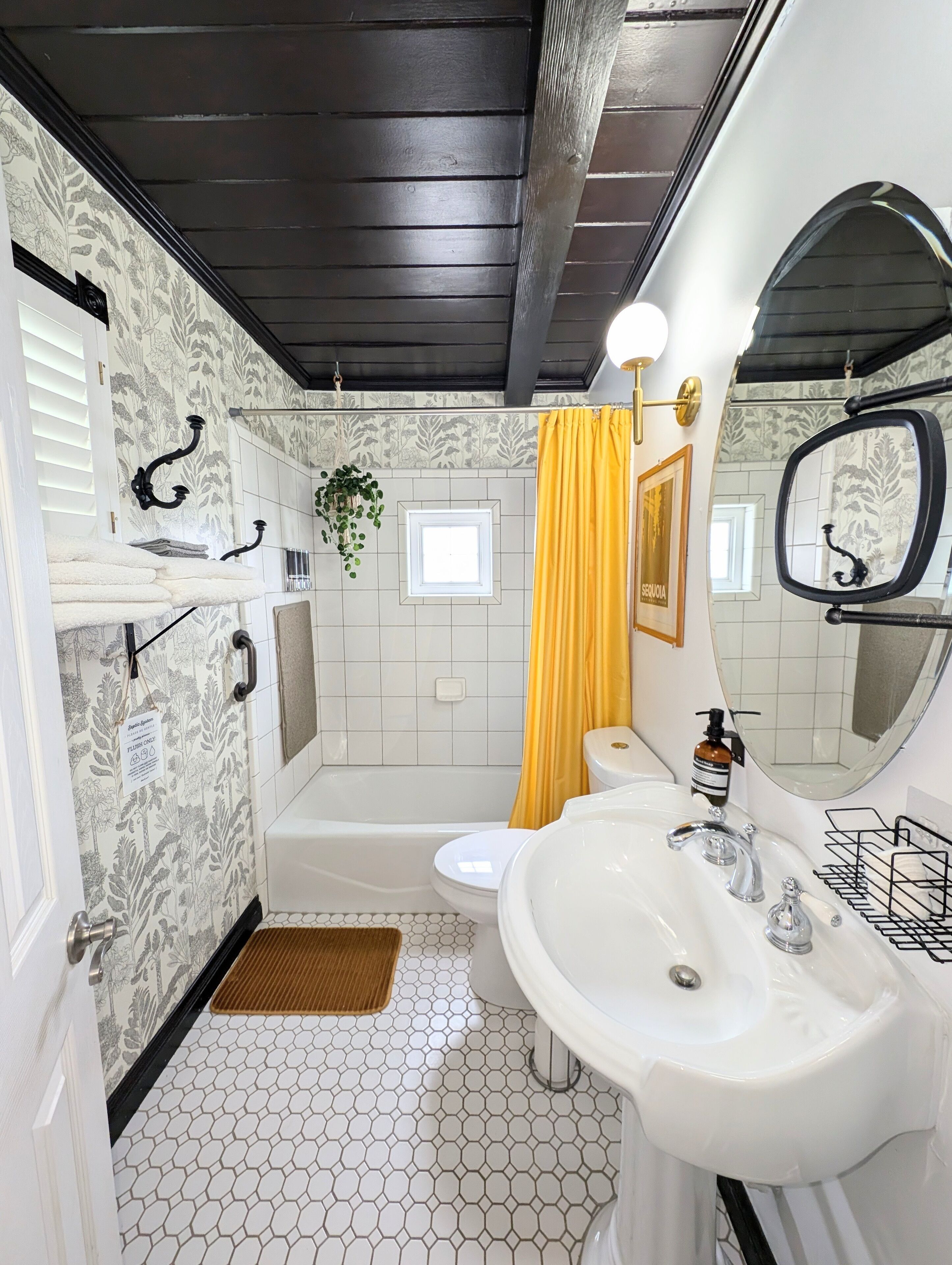 Une salle de bain avec une baignoire, un lavabo, des toilettes et un miroir.