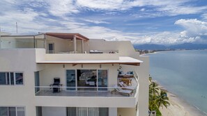 Um edifício moderno de vários andares com varanda com vista para a praia.