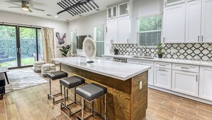 A modern kitchen with a large island, bar stools, and a view of the outdoors. - "Stunning Home New Listing in the shadows of Downtown Houston A must SEE" (Houston)