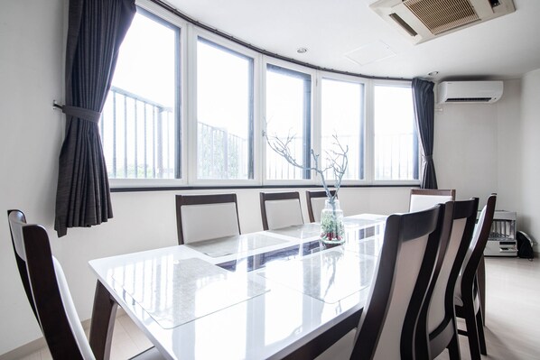 A conference room with a glass table, six chairs, and large windows with curtains. - ROADSIDE HOUSE (Sapporo)