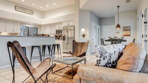 A modern kitchen with white cabinets, a central island, and a bar area. - Rancho Relaxo | 3 Acres + Casita + Pool (Scottsdale)