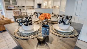 A dining table set with white plates, blue and black patterned cups, and a vase with orange flowers. - Rancho Relaxo | 3 Acres + Casita + Pool (Scottsdale)