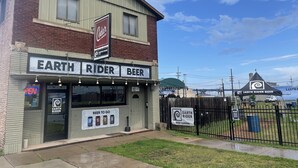 Um edifício com uma placa que diz "Earth Rider Beer" e "Cedar Lounge".