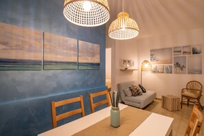 A dining area with a table, chairs, and artwork on the walls.