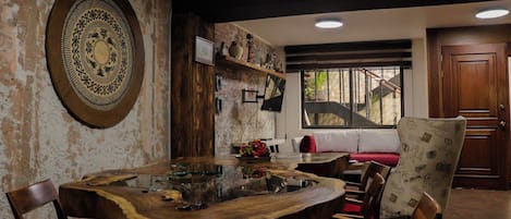 Un comedor con una mesa de madera, sillas y un elemento decorativo grande en la pared.